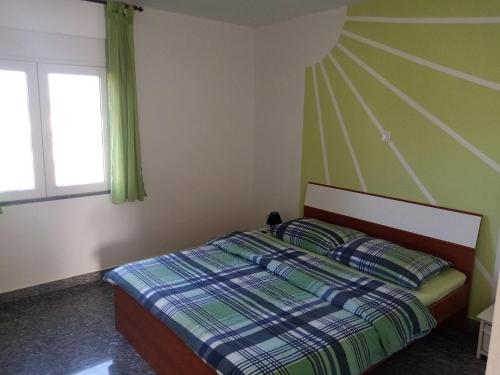 a bedroom with a bed with a green wall at Apartment Buic in Pula