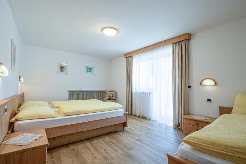 Un dormitorio con dos camas y una ventana. en Residence Crazzolara, en La Villa