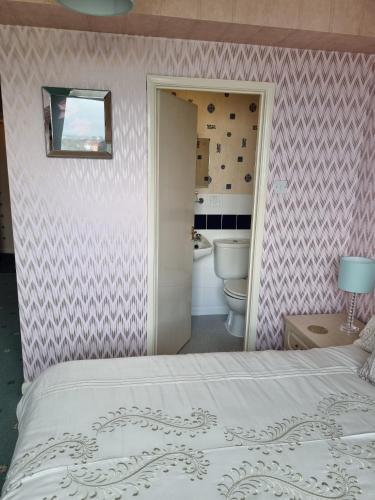 a bedroom with a bed and a bathroom at The Sands Hotel in Paignton