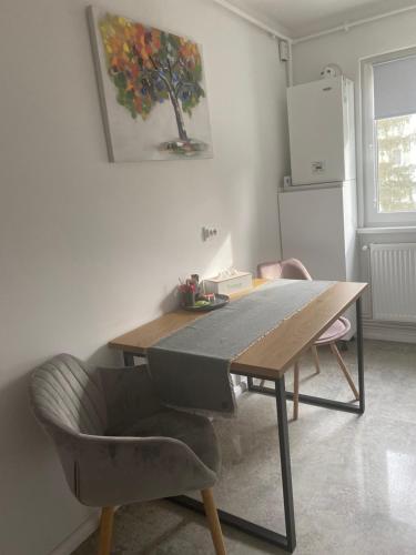 a table and chairs in a kitchen with a painting on the wall at Astra 1bedroom in Braşov