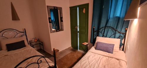 a small room with two beds and a window at Atlantic Hostel in Essaouira