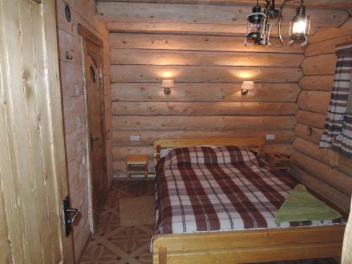 a room with a bed in a wooden cabin at АртГір гостинний двір in Mykulychyn