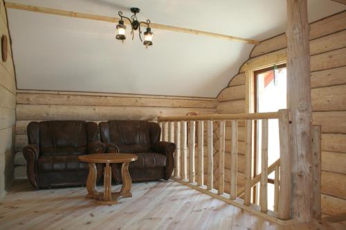 a living room with a leather couch and a table at АртГір гостинний двір in Mykulychyn