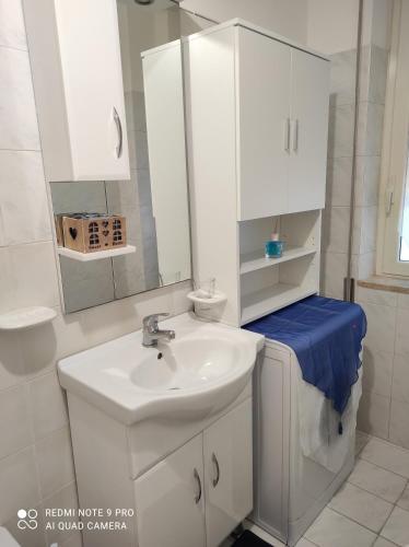 Baño blanco con lavabo y espejo en TamarHouse Sperlonga Casa Noemi, en Sperlonga
