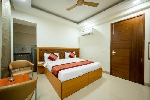 a bedroom with a bed and a chair and a desk at The Palms Inn I Near Medanta Medicity I Sec-38 in Gurgaon