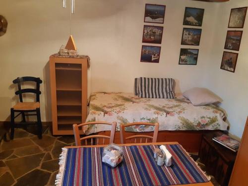 a bedroom with a bed and two chairs and a table at Kouros Villa! in Paltsi Pilion