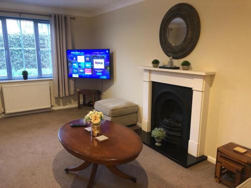 a living room with a table and a fireplace at Waller House in Norwich