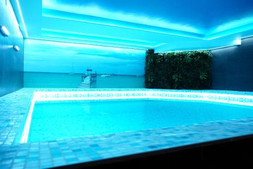 a swimming pool in a house with blue lighting at Hotel & Spa Villa Meydan in Mostar