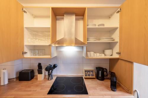 a kitchen with wooden cabinets and a stove top oven at ☆ Modern stylish flat in central location in Wilhelmshaven