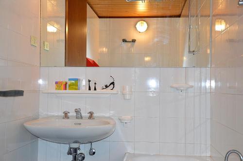 a white bathroom with a sink and a mirror at Marilleva 1400 in Marilleva