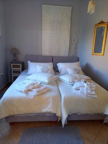 a bed with white sheets and towels on it at Chris Villa in Perdhika