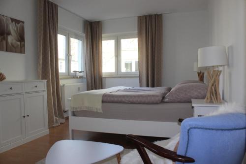 um quarto com uma cama, uma cadeira e uma janela em Ferienapartment Alma em Erfurt