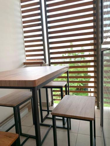 une table et des bancs dans une pièce avec fenêtres dans l'établissement Appartement T2 Très bon standing vue mer, à Sainte-Clotilde