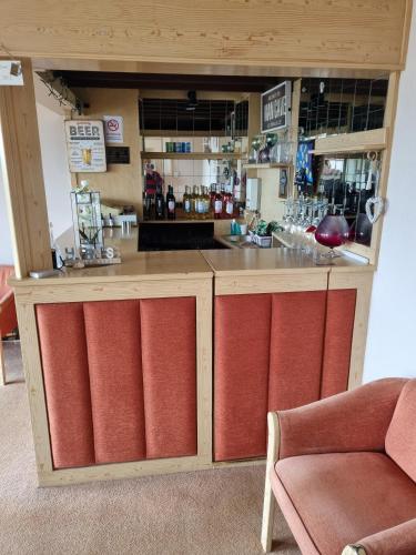 a wooden bar with red cushions in a room at The Sands Hotel in Paignton