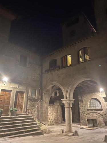 a stone building with stairs and a door at night at L'Albero della Vita in Viterbo