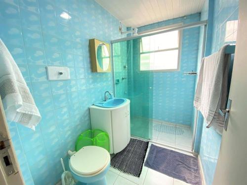 uma casa de banho azul com um WC e um chuveiro em BPT22 - Quadra Mar, Climatizado, TV Smart, Wi-Fi em Balneário Camboriú