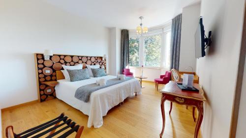 a bedroom with a large bed with a wooden headboard at Villa Elisa M in Aubenas