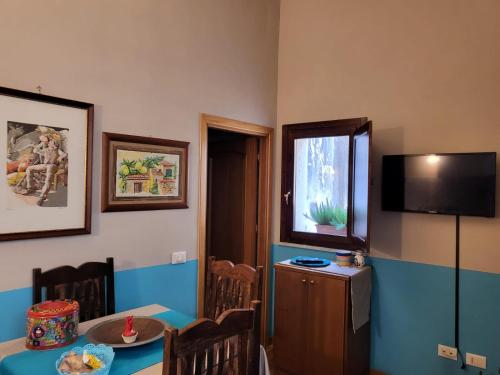 a dining room with a table and a television at Casa da Michelino in Palermo
