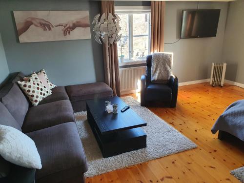 a living room with a couch and a coffee table at Bergsmansgårdens Gästhus in Asphyttan