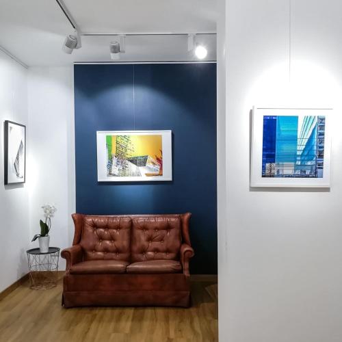 - un canapé en cuir brun dans une chambre avec un mur bleu dans l'établissement OTTO Rooms & Photogallery, à Rome