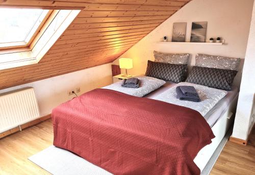 a bedroom with a red bed in a attic at Chagall - helles und gemütliches Appartement in Uninähe in Mainz
