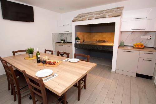 Tugare的住宿－Apartment Maya Bellissima，厨房配有木桌、椅子和桌子。