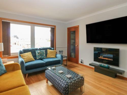 a living room with a couch and a tv at Paradise Place in Perth