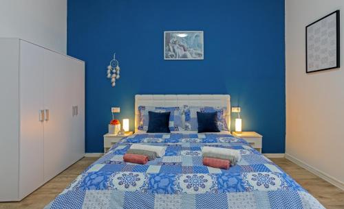 a blue bedroom with a large bed with blue walls at Rich apartment in Pula