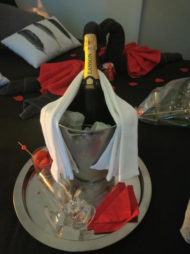 a bottle of wine on a plate on a table at Jacuhomespa13 in Vitrolles