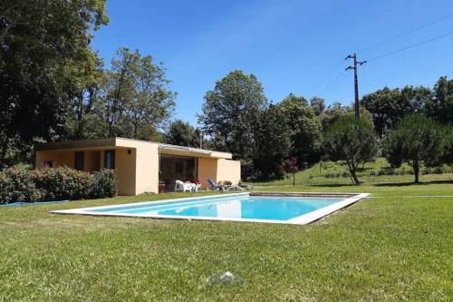 a house with a swimming pool in the grass at LIMA COTTAGES - Casa do Cercado in Arcos de Valdevez
