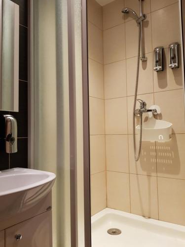 a bathroom with a shower and a sink at Trumpalaikė buto nuoma,apgyvendinimas - bekontaktis įėjimas in Rokiškis