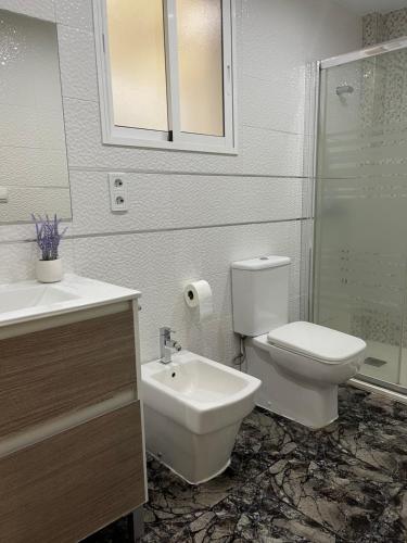 a bathroom with a toilet and a sink at UIM Mediterraneo Juana Wifi in Puerto de Sagunto