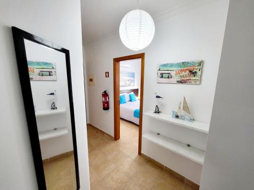 a mirror in a room with a bedroom at Apartamento Praia Fuseta 3 - Ria Formosa in Olhão