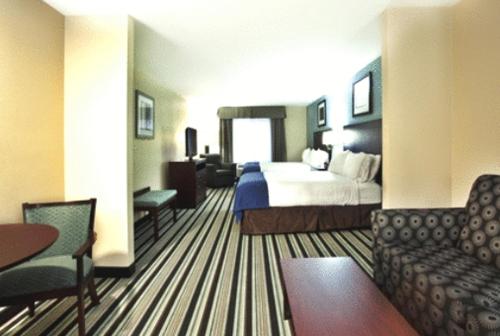 a hotel room with a bed and a couch and a table at Holiday Inn Express Hotel & Suites Baton Rouge -Port Allen by IHG in Port Allen