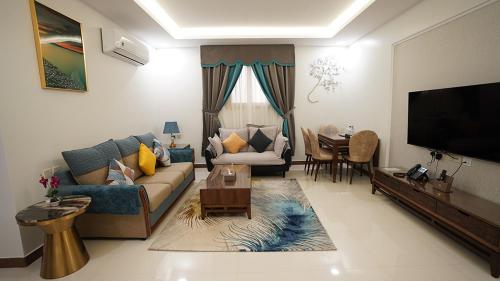 a living room with a couch and a flat screen tv at مواسم للأجنحة الفندقية in Al Kharj