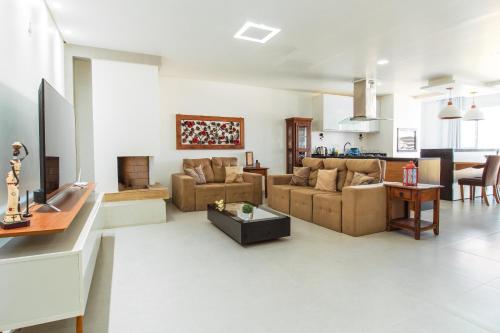 a living room with two couches and a kitchen at Apto. 3 dorm. entre Praia da Cal e Lagoa Violão in Torres