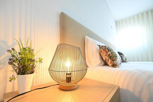 a lamp on a table next to a bed at O Visconde - Alojamento local in Lamego