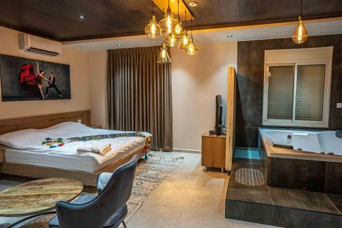 Layan Boutique Hotel في مجدل شمس: غرفة نوم مع سرير وحوض استحمام ومغسلة