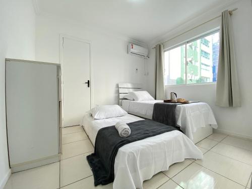 een hotelkamer met 2 bedden en een raam bij WAL51 - Churrasq, Quadra Mar, 3 Dorm, Climatizado in Balneário Camboriú