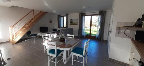 une salle à manger et un salon avec une table et des chaises dans l'établissement LA CHOUETTE, à Neuville-Bosc