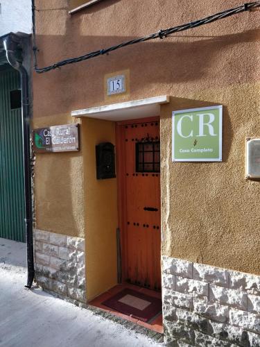 a front door of a building with a sign on it at CASA RURAL EL CAIDERÓN in Ambel