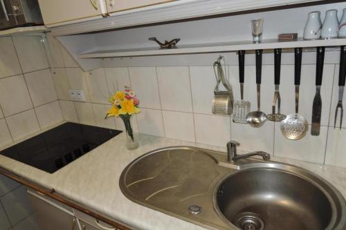 a kitchen counter with a sink and a vase of flowers at Semi-detached house, Kolczewo in Kołczewo
