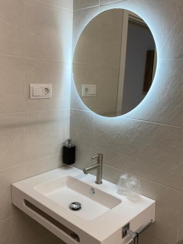 een badkamer met een wastafel en een spiegel bij Pension Rovior in Calafell