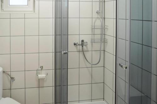 a shower in a bathroom with white tiles at Bungalow, Kolczewo in Kołczewo