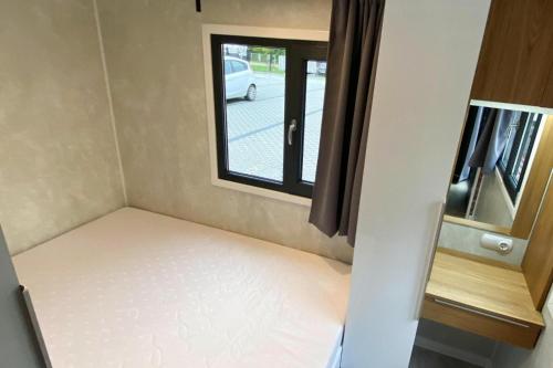 Kleines Zimmer mit einem Bett und einem Fenster in der Unterkunft Bungalows, Dziwnow in Dziwnów