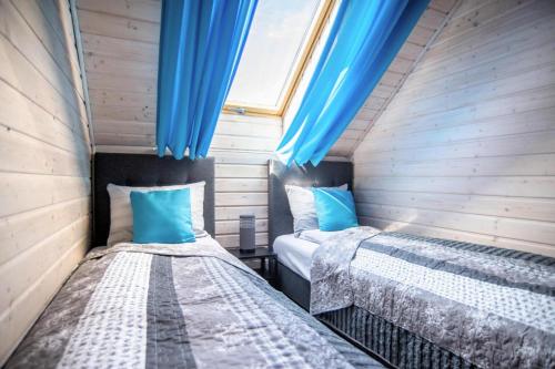 2 letti in una camera con tende blu di Holiday complex, Rewal a Rewal