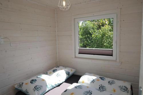 ein Zimmer mit zwei Betten und einem Fenster in der Unterkunft Bungalow in Kolczewo near Baltic Sea in Kołczewo