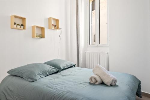 un animal farci est assis sur un lit dans une pièce dans l'établissement Appartement 2P centre de Cannes avec balcon, à Cannes