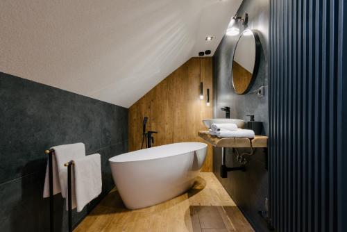 a bathroom with a large white tub and a sink at Chaloupka u řeky in Frýdlant nad Ostravicí