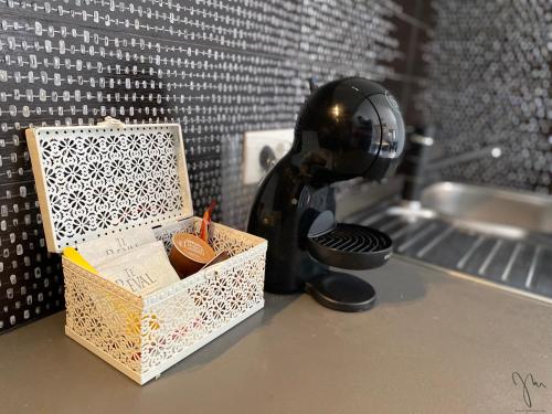 a black coffee maker next to a box on a counter at jm-Sutomišćica-holiday house on the beach in Sutomišćica